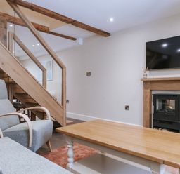 A living room with a staircase and fireplace at Bluck's cottage St. Agnes