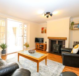 A living room with a table and sofa at Honeysuckle Cottage in Swaffham
