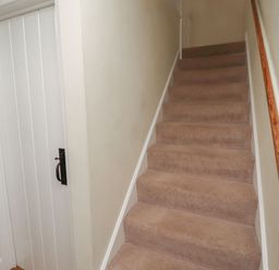 A staircase leading up with a door at the side at Honeymug in Branton near Powburn