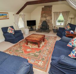 A living room with a coffee table and fireplace at Honeymug in Branton near Powburn