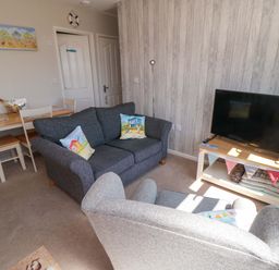 A living room with a sofa and television at Beach House 
