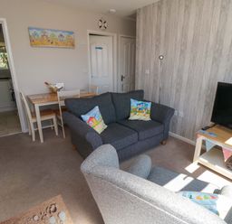 A living room with furniture and a television at Beach House