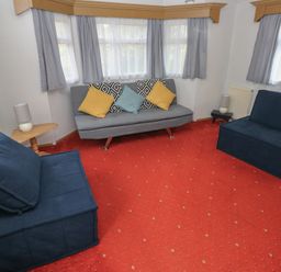 A living room with seating and a lamp at Static Caravan in 
