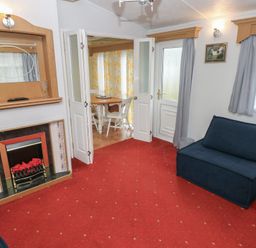 A living room with a sofa and a fireplace at Static Caravan
