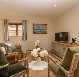 A living room with a tv and sofa at The Annex in Burford