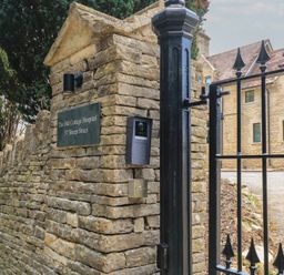 A gate with intercom and nameplate at The Old Cottage Hospital Annexe in Burford