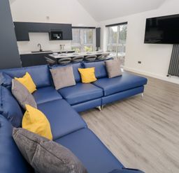 A living room with a sofa and kitchen area at Cottage 1 in Laugharne
