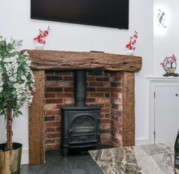 A fireplace with a stove and wooden mantel in a living room at Aspen Boutique