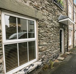 A stone building with a window and door at Aspen Boutique