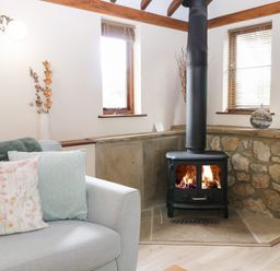 A living room with a stove and sofa at WEST LODGE in Ashford