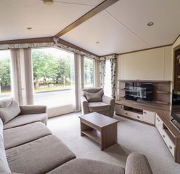 A living room with a sofa and a television at Beach Retreat E19 Dyffryn Seaside Estate Dyffryn Ardudwy