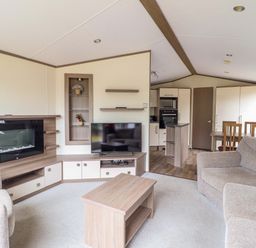 A living room with a sofa, coffee table, and television at Beach Retreat E19 Dyffryn Seaside Estate, Dyffryn Ardudwy