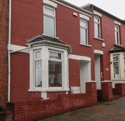 A red brick house exterior with multiple windows at Gavin and Stacey House in Barry