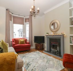 A living room with a sofa and armchairs at Gavin and Stacey House in Barry
