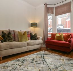 A living room with a sofa and armchair at Gavin and Stacey House in Barry