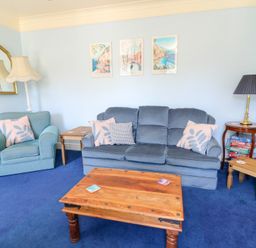 A living room with a sofa and chair at Ty Caredig in Swansea