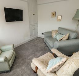 A living room with seating and a television at 13 School Road, Newton Abbot