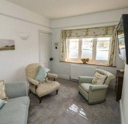 A living room with a sofa and armchair at 13 School Road in Newton Abbot