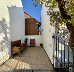 A patio area with wooden seating at The Cottage in Bournemouth