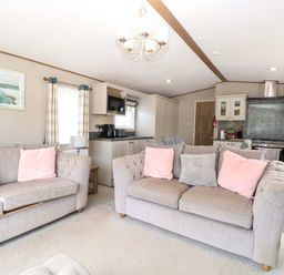 A living room with couches and kitchen area at 17 Castle Walk in Great Yarmouth