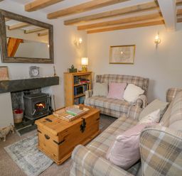A living room with a fireplace and seating area at Brondderwen in Blaenau Ffestiniog
