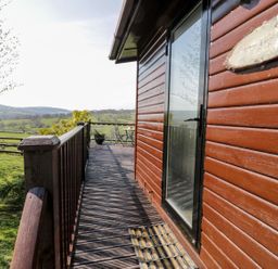 An outdoor area with a wooden deck and a view of the landscape at Summertime Lodge Rhyd-y-Foel near Abergele