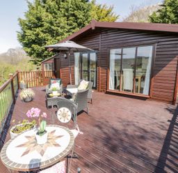 A deck with chairs and a table at Summertime Lodge Rhyd-y-Foel near Abergele
