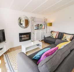 A living room with a sofa and television at Summertime Lodge Rhyd-y-Foel near Abergele