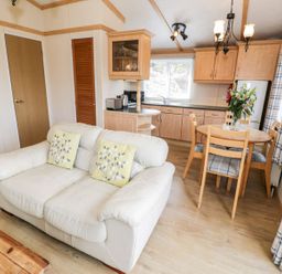 A living room with a couch and dining area at Alpine Lodge Rhyd-y-Foel near Abergele