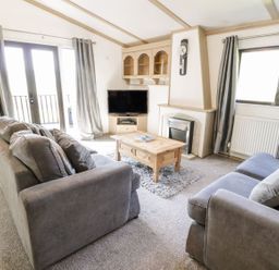 A living room with a sofa and coffee table at Springtime Lodge Rhyd-y-Foel near Abergele