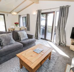 A living room with a sofa and coffee table at Springtime Lodge Rhyd-y-Foel near Abergele