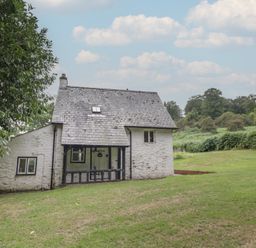 A house with a front porch and yard at Hillside Cottage 