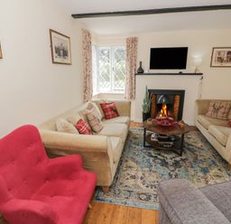 A living room with sofas and a fireplace at Hillside Cottage
