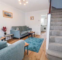 A living room with a staircase and furniture at 23 The Maltings in Weymouth