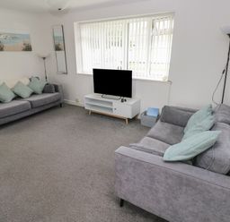 A living room with a sofa and TV at Chalet 26 in Scurlage