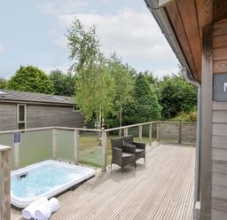 An outdoor area with a hot tub and seating at 3 Meadow Retreat in Liskeard