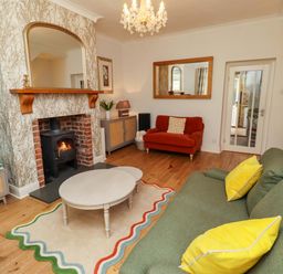A living room with a fireplace and seating area at Rose Briar Cottage in Morpeth