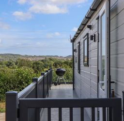A deck with a barbecue at Maple Lodge in Teigngrace near Kingsteignton