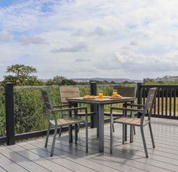 An outdoor dining area with a table and chairs at Maple Lodge in Teigngrace near Kingsteignton
