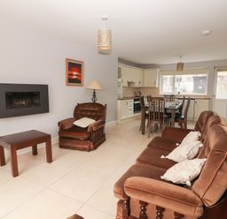 A living room with a sofa and armchair at 1 Windermere in Kinvarra