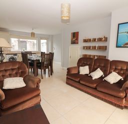 A living room with a sofa and dining table at 1 Windermere in Kinvarra
