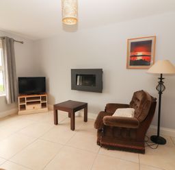 A living room with a television and a sofa at 1 Windermere in Kinvarra