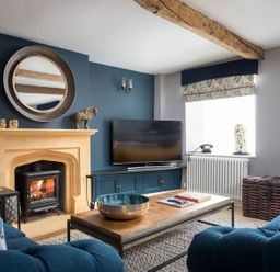 A living room with a fireplace and television at Lavender Cottage (Stow-on-the-Wold) Cheltenham