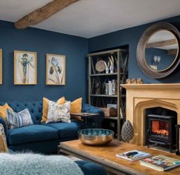 A living room with a blue sofa and fireplace at Lavender Cottage (Stow-on-the-Wold) Cheltenham