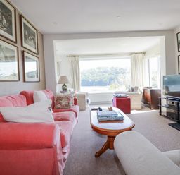 A living room with a sofa, coffee table, and television at Kiln Cottage in Golant near Tywardreath