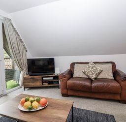 A living room with a couch and television at Valley Lodge 20 in Callington