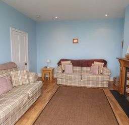 A living room with two sofas and a fireplace at Glen Avon in Seahouses