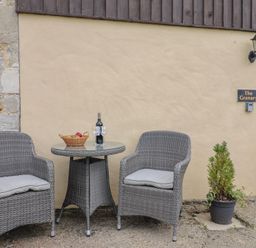 Chairs and table with wine and fruit at The Granary in Wyke Nr Axminster