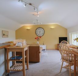 A living room with a sofa and dining area at The Granary Wyke Nr Axminster