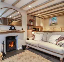 A living room with a fireplace and a sofa at Woodedge in Porlock